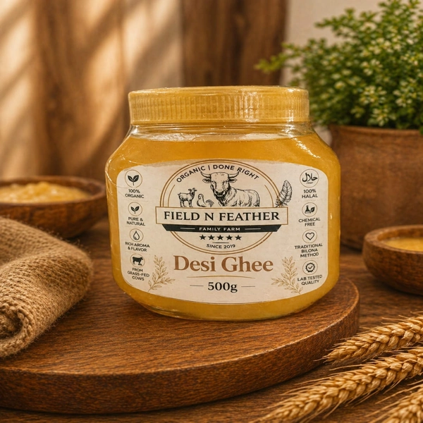 A 500g jar of textured golden Desi Ghee with a Field N Feather label, featuring farm animal illustrations and organic certifications.